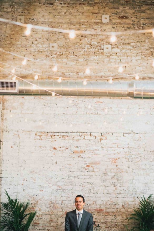 a photo of jacob standing in front of a beautiful brick wall