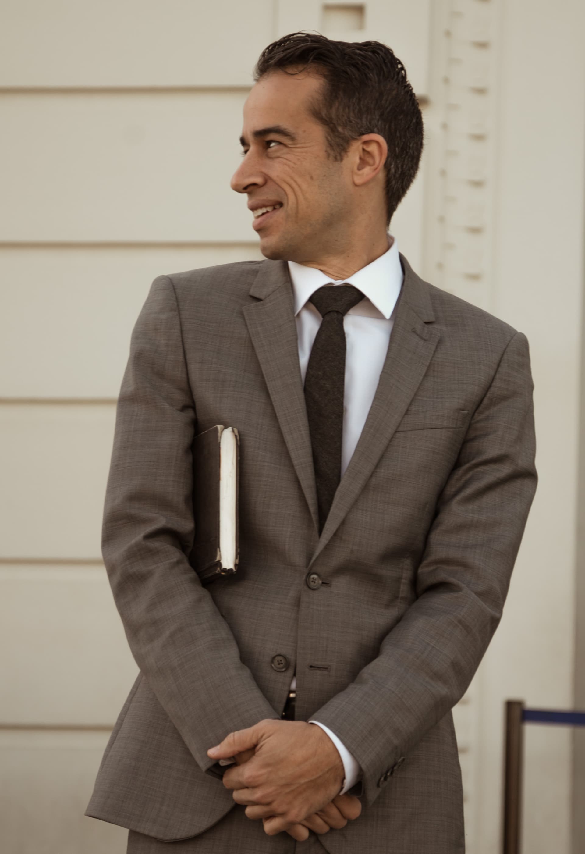 a photo of jacob looking to his side with this officiant book tucked under his arm